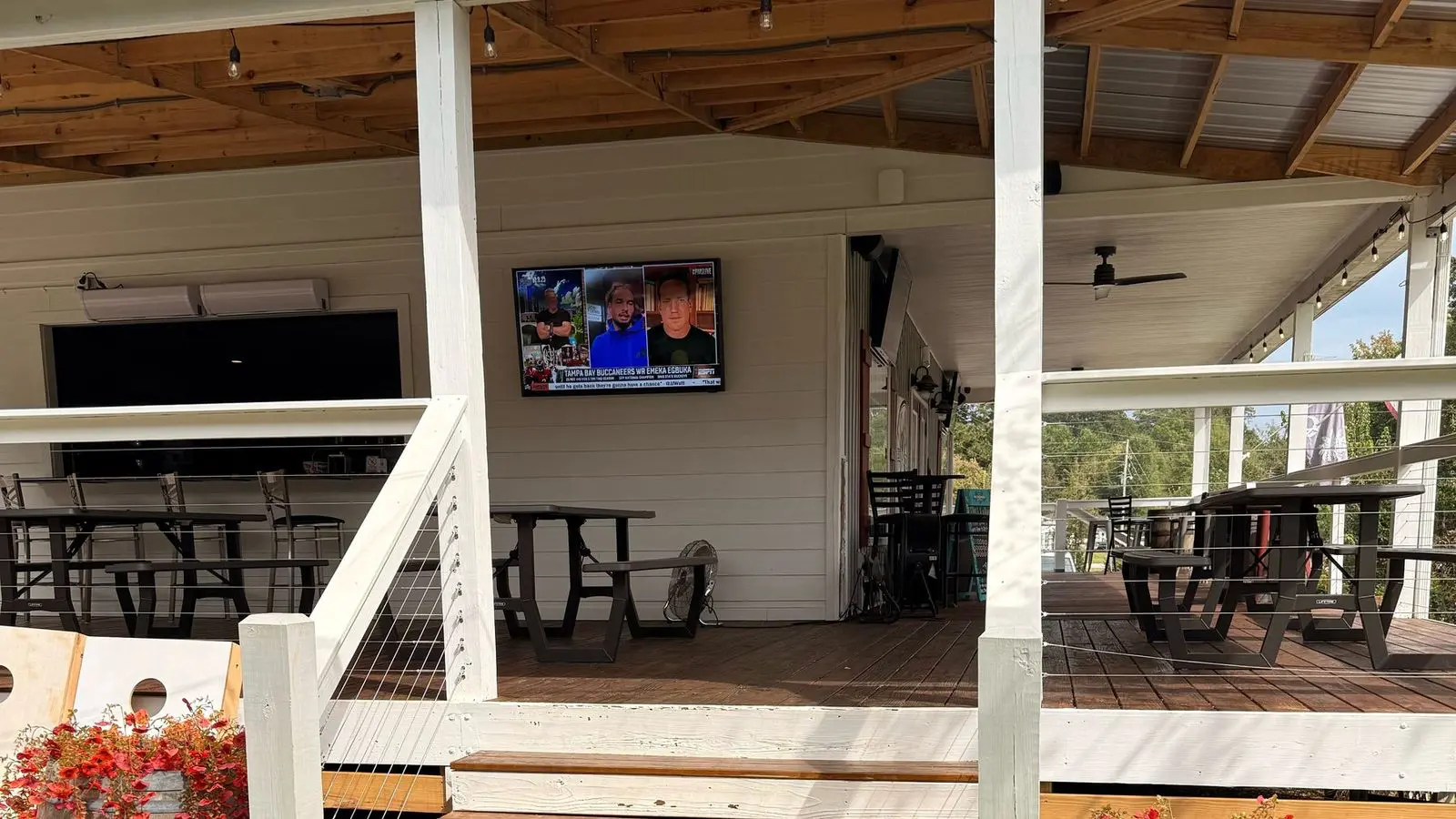 Front porch steps with barrels and a TV