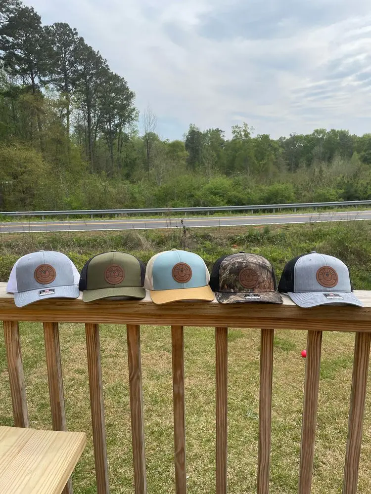Lazy Creek leather patch trucker hats on the porch rail